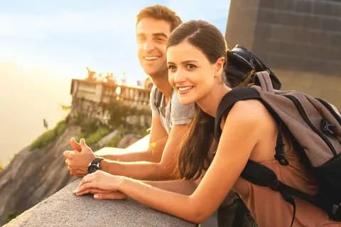 Zwei Personen mit Rucksäcken, die an einem Geländer stehen.