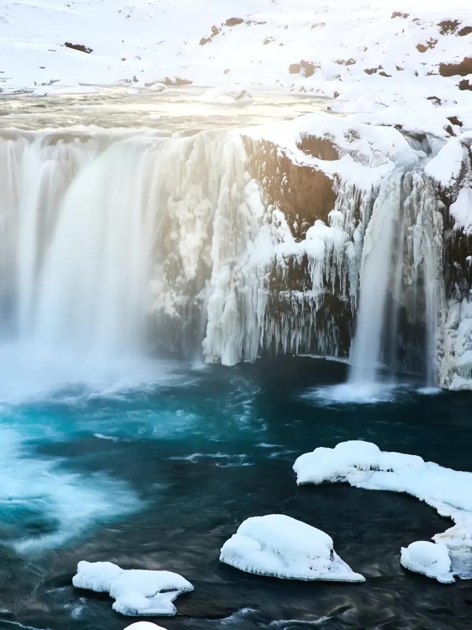 Wasserfälle in Island, mit schneebedecktem Hintergrund.