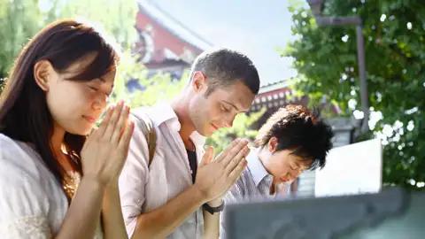 Auf unserer Marco Polo Rundreise durch Japan legen wir wie die Einheimischen am Asakusa-Tempel in Tokio eine Pause zum Innehalten ein.