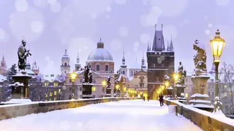 Auf unserer YOUNG LINE TRAVEL Reise nach Prag erleben wir immer wieder magische Momente, wie hier in der Dämmerung auf der schneebedeckten Karlsbrücke.